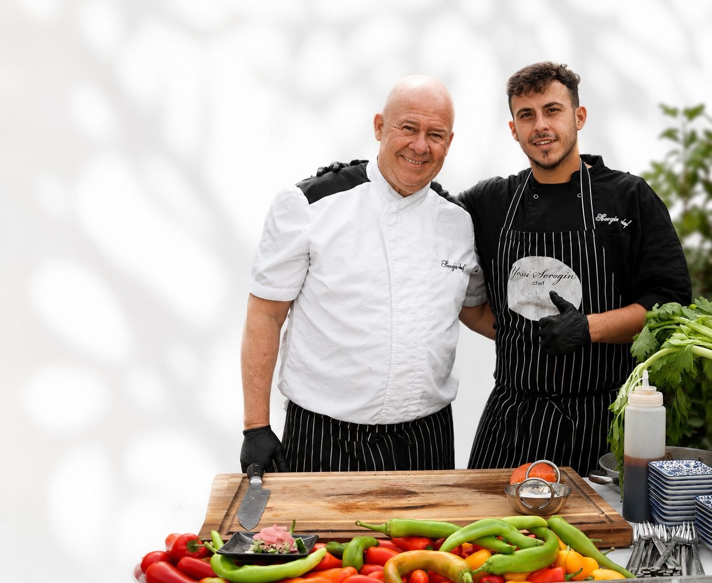 שפי Sorozin Chef לפני שולחן עמוס ירקות טריים, מוכנים להכנת האירוע